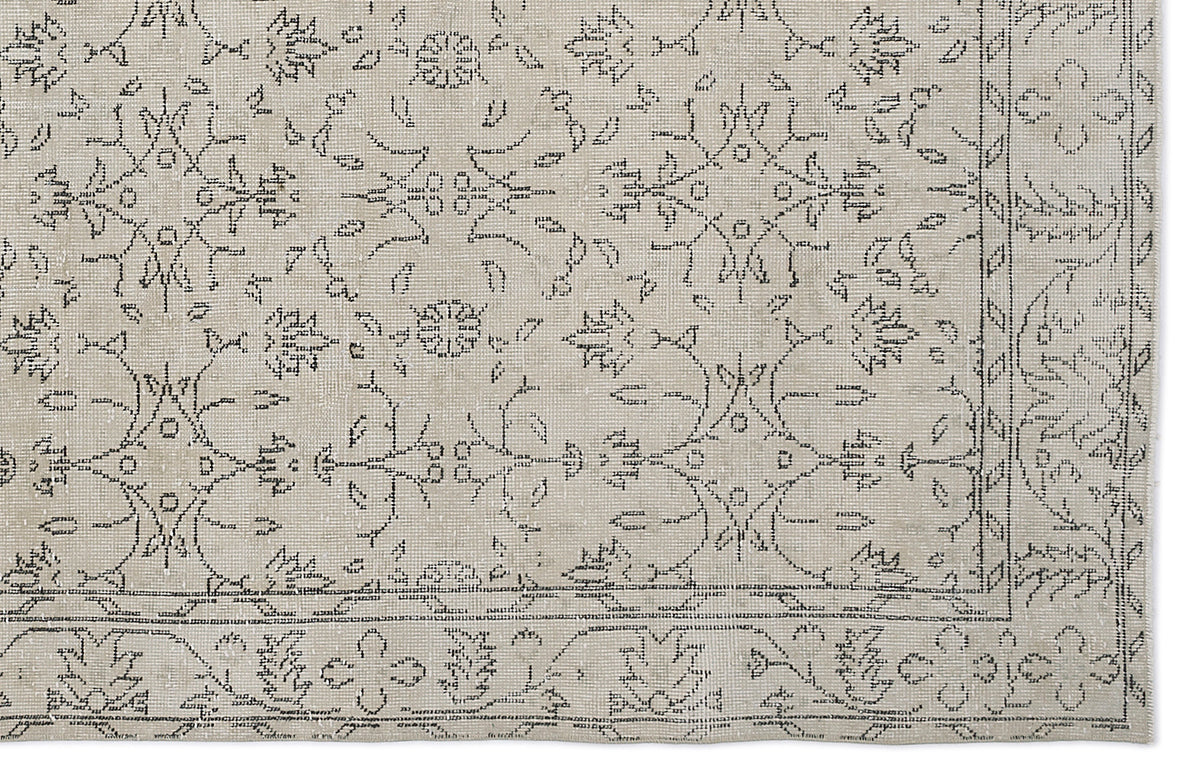 Beige rug with a black line-art floral medallion pattern and a decorative border.