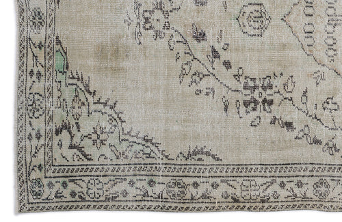 Load image 1 in gallery view. Beige vintage-style rug with a distressed black floral medallion pattern and subtle green accents.