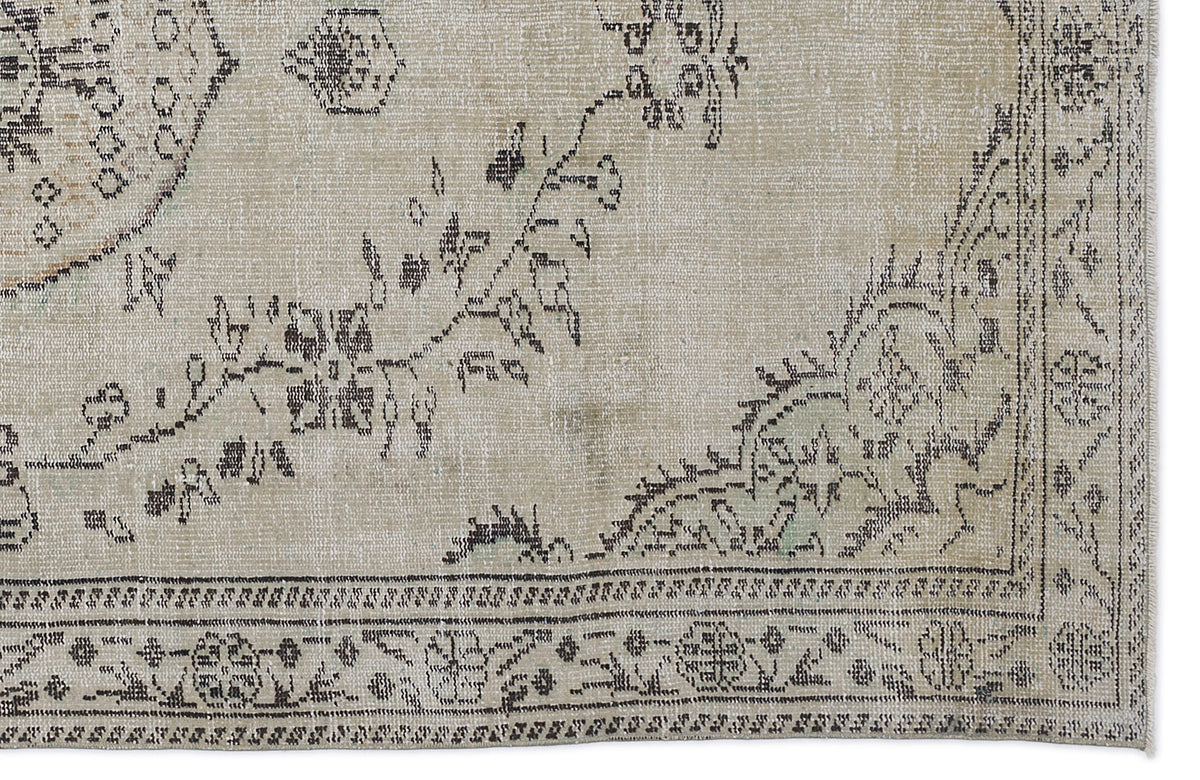 Beige and charcoal grey vintage-style rug with a distressed floral medallion pattern and a detailed border.