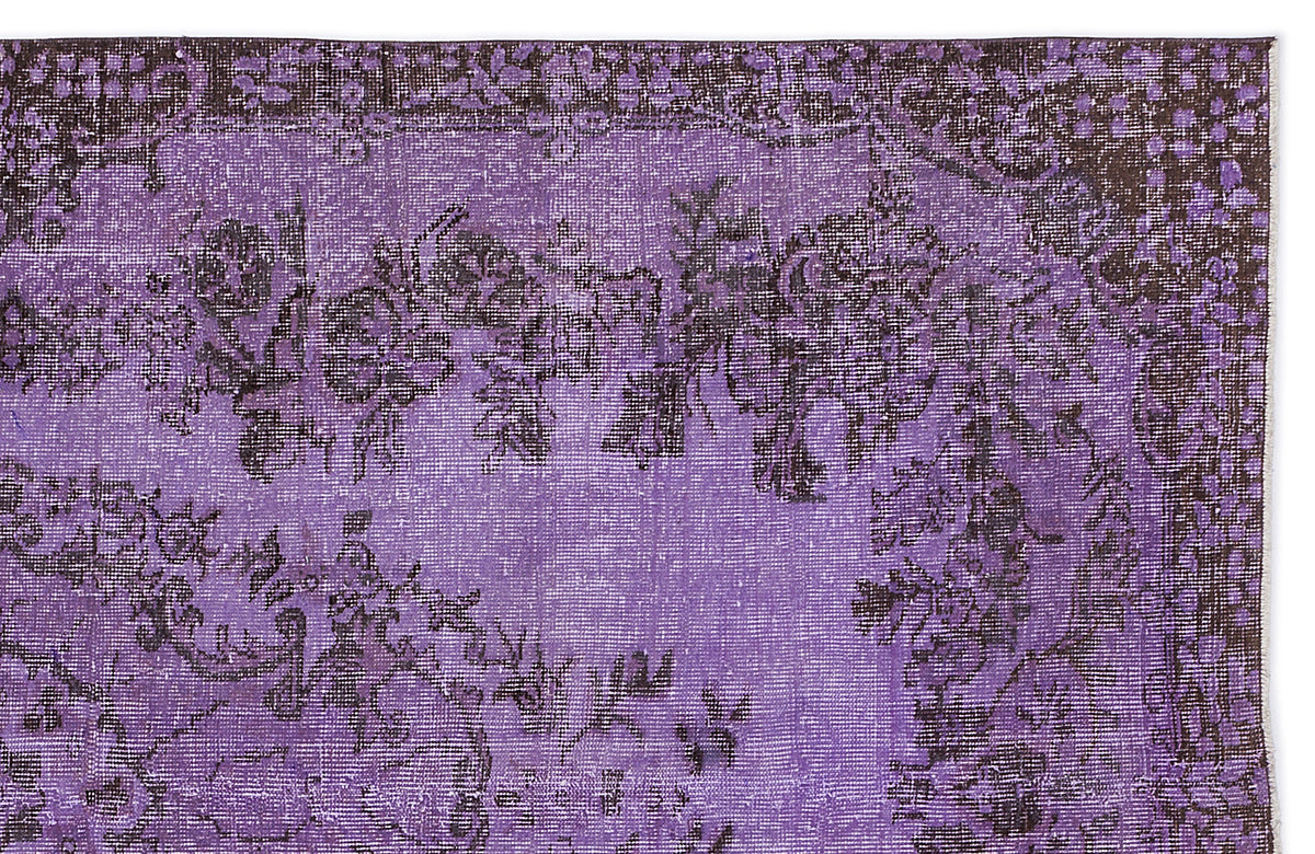 Distressed purple and black vintage-style rug with a floral medallion pattern.