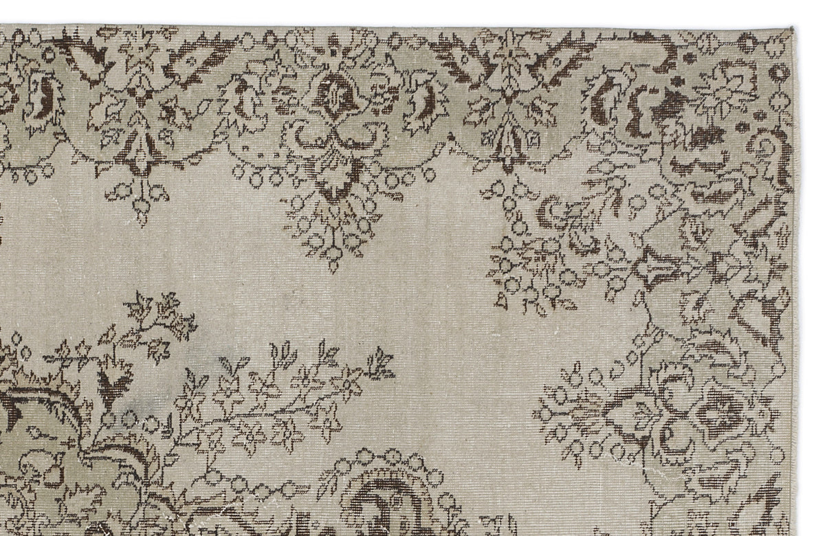 Beige rug with a dark brown distressed floral and vine pattern.