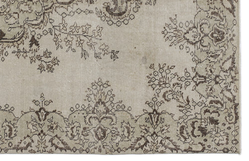 Load image 1 in gallery view. Beige rug with a dark brown distressed floral medallion pattern and a fringed edge.
