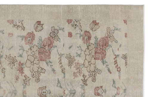 Load image 1 in gallery view. Beige vintage-style rug with a faded floral pattern in muted red, green, and brown tones.