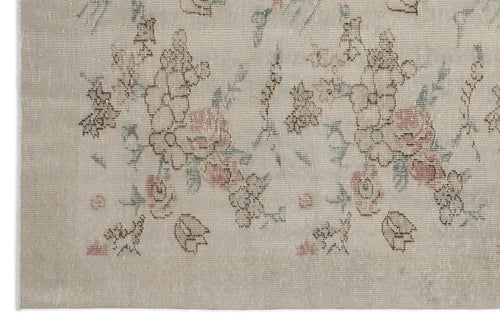 Load image 1 in gallery view. Beige rug with a distressed floral pattern in muted pink, brown, and sage green.
