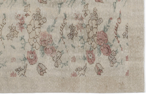 Load image 1 in gallery view. Beige rug with a distressed floral pattern in muted red and sage green.