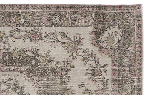 Load image 1 in gallery view. Distressed beige rug with a dark brown border and faded floral vine pattern in muted pink and sage green.
