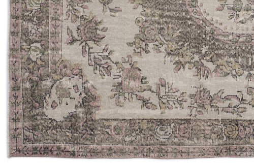 Load image 1 in gallery view. Distressed beige rug with a faded floral medallion pattern in muted pink, olive green, and charcoal grey.
