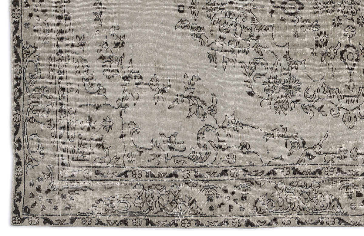 Distressed beige and charcoal grey rug with a traditional floral medallion pattern and ornate border.