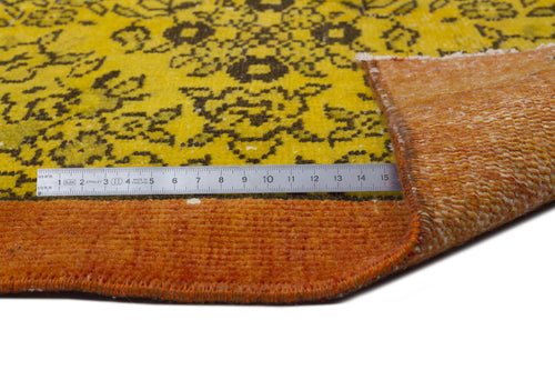 Load image 1 in gallery view. Yellow and brown floral patterned rug with a folded corner revealing an orange backing and a metal measuring ruler.