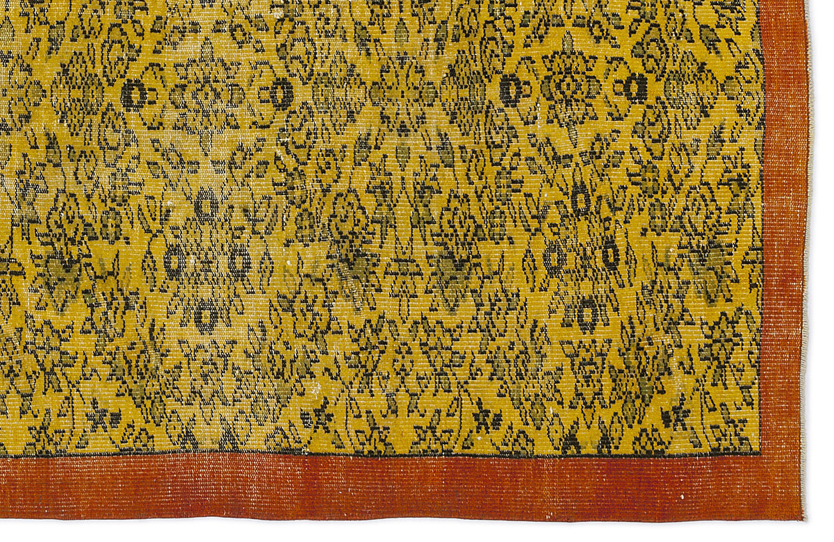 Mustard yellow rug with a black floral medallion pattern and a solid burnt orange border.
