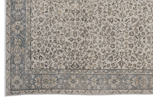 Load image 1 in gallery view. Beige and slate blue rug with a distressed traditional floral pattern and a decorative border.
