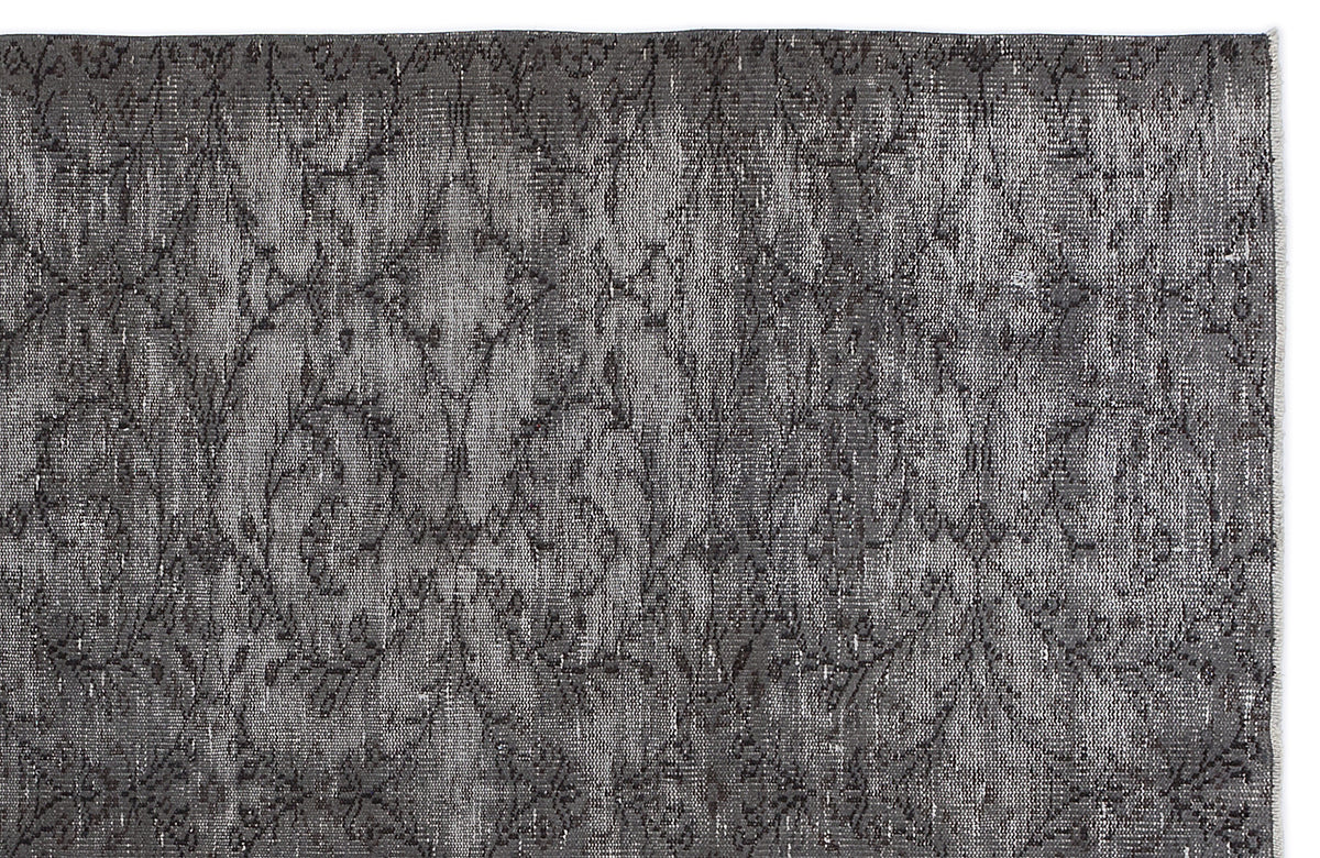 Charcoal grey rug with a distressed, repeating damask pattern on a white background.