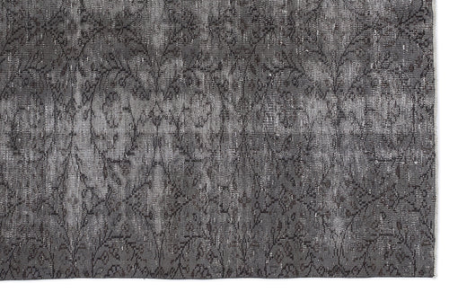 Load image 1 in gallery view. Charcoal grey distressed rug with a faded, repeating floral medallion pattern.