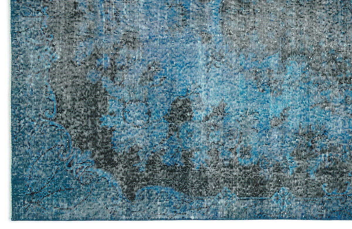 Blue and black distressed rug with a faded, abstract vintage-inspired pattern.