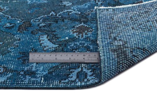 Load image 1 in gallery view. Blue and black distressed floral pattern rug with a corner folded back to show the woven backing and a metal ruler.