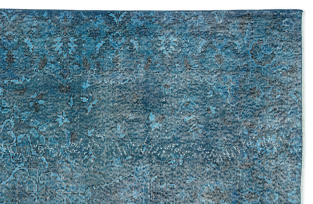 Deep blue distressed rug with a faded traditional floral medallion pattern on a white background.