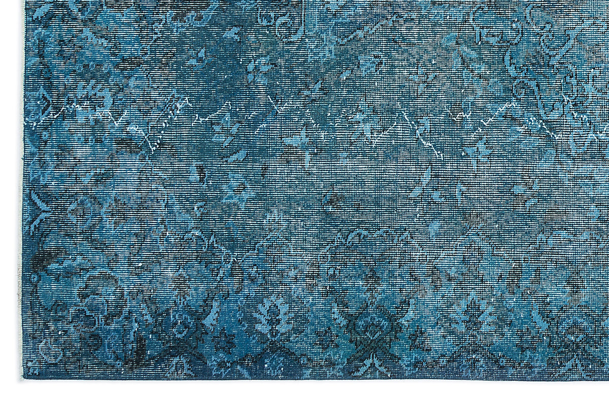 Deep blue distressed rug with a faded traditional floral medallion pattern.