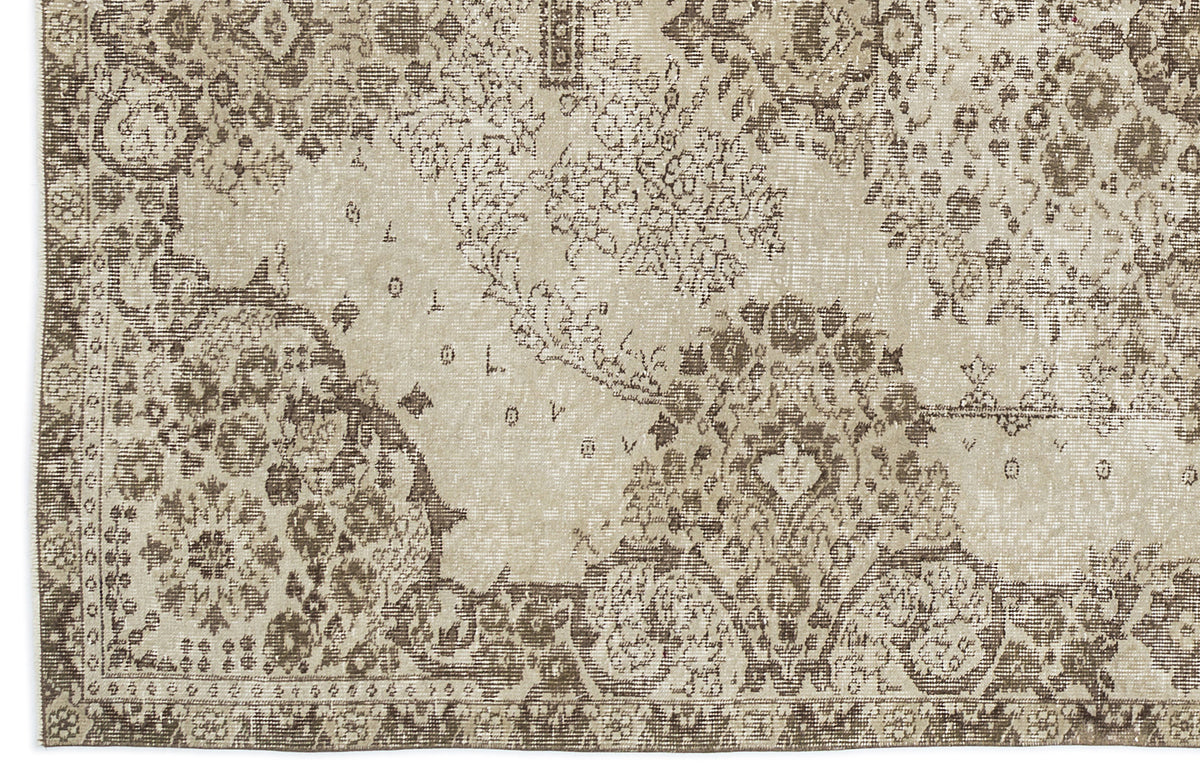 Beige and brown distressed rug with a faded traditional floral medallion pattern.