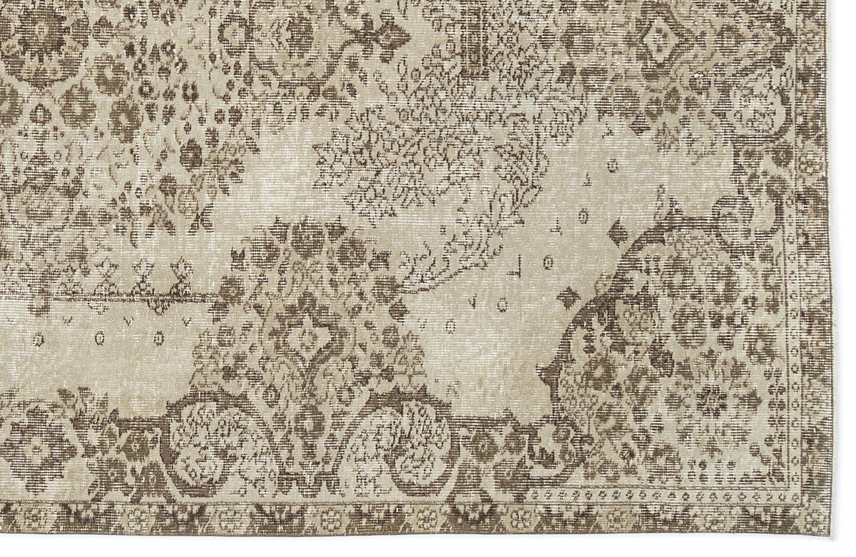 Beige and brown distressed rug with a faded traditional floral medallion pattern.