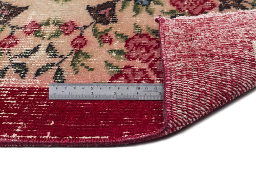 Load image 1 in gallery view. Floral rug with a pink and red distressed pattern, showing the woven backing and a metal ruler for scale.