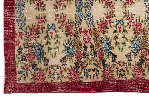 Load image 1 in gallery view. Beige rug with a distressed floral pattern in red, blue, and yellow, featuring a solid red border.