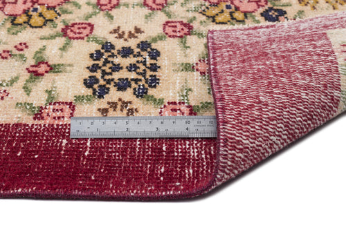 Load image 1 in gallery view. Beige rug with a floral pattern in pink, yellow, and blue, featuring a deep red border and a metal ruler for scale.