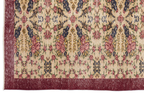 Load image 1 in gallery view. Beige rug with a distressed floral medallion pattern in pink, navy, and green, featuring a solid deep red border.