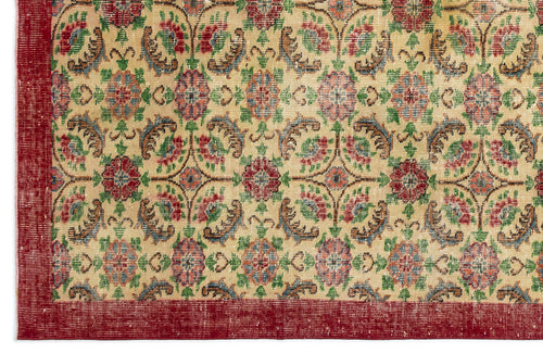Load image 1 in gallery view. Beige rug with a repeating floral medallion pattern in red, green, and blue, featuring a solid red border.