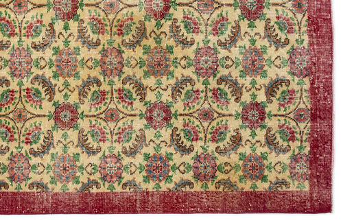 Load image 1 in gallery view. Beige rug with a repeating floral medallion pattern in red, green, and blue, featuring a wide red border.
