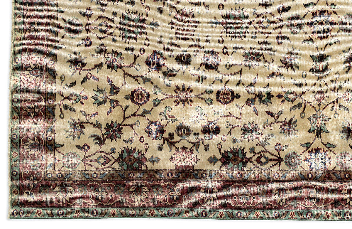 Beige traditional rug with a floral vine pattern in red, blue, and green, featuring a detailed decorative border.