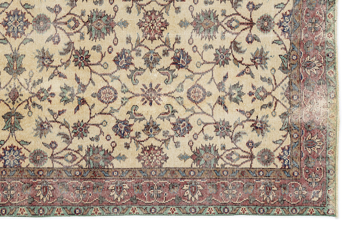 Beige traditional rug with a floral vine pattern in red, blue, and green, featuring a wide decorative border.