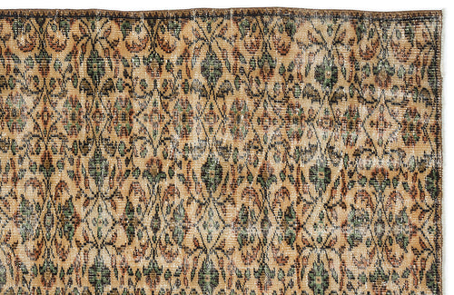 Load image 1 in gallery view. Tan, green, and black vintage-style rug with a repeating distressed diamond and floral medallion pattern.
