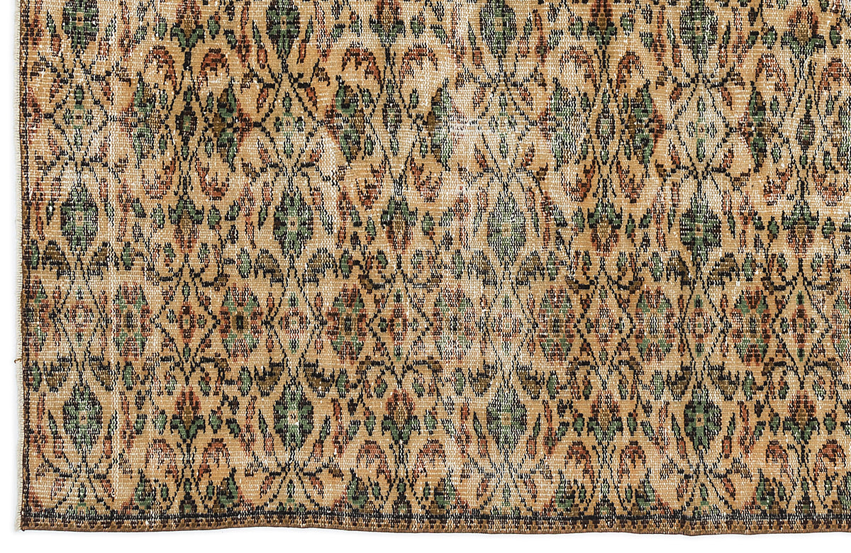 Tan, green, and rust-colored vintage-style rug with a repeating diamond lattice and floral medallion pattern.