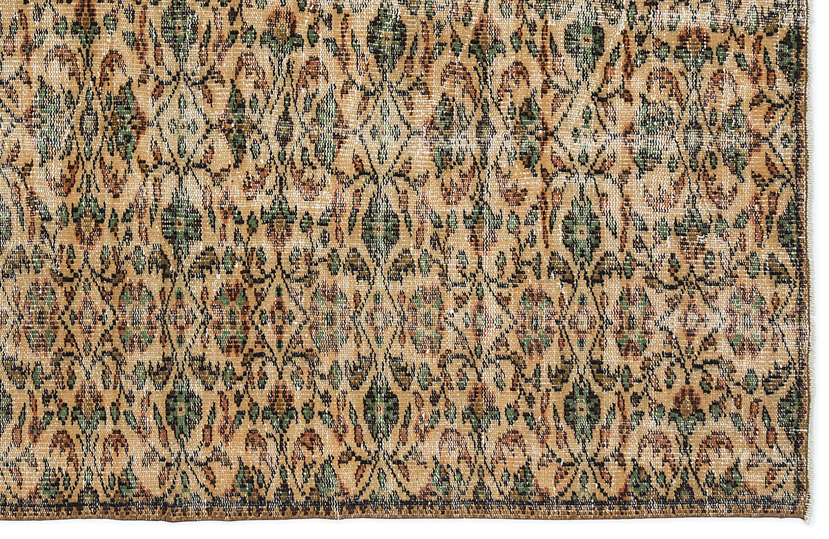 Tan, green, and rust-colored vintage-style rug with a repeating diamond lattice and floral medallion pattern.