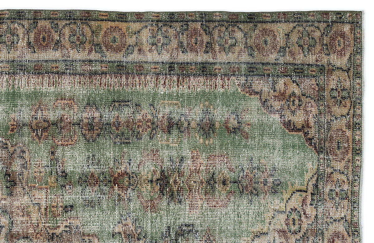 Distressed sage green rug with a faded traditional floral medallion pattern and a decorative border.