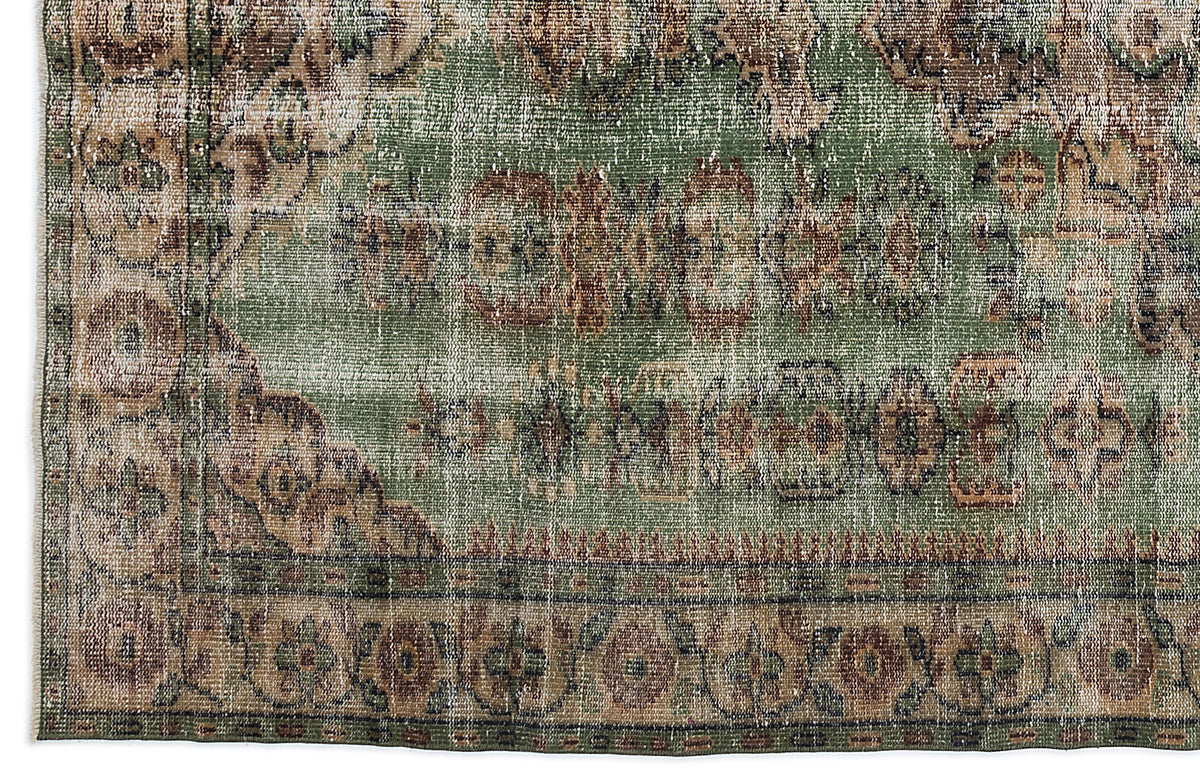 Distressed sage green rug with a faded brown and beige traditional medallion border pattern.