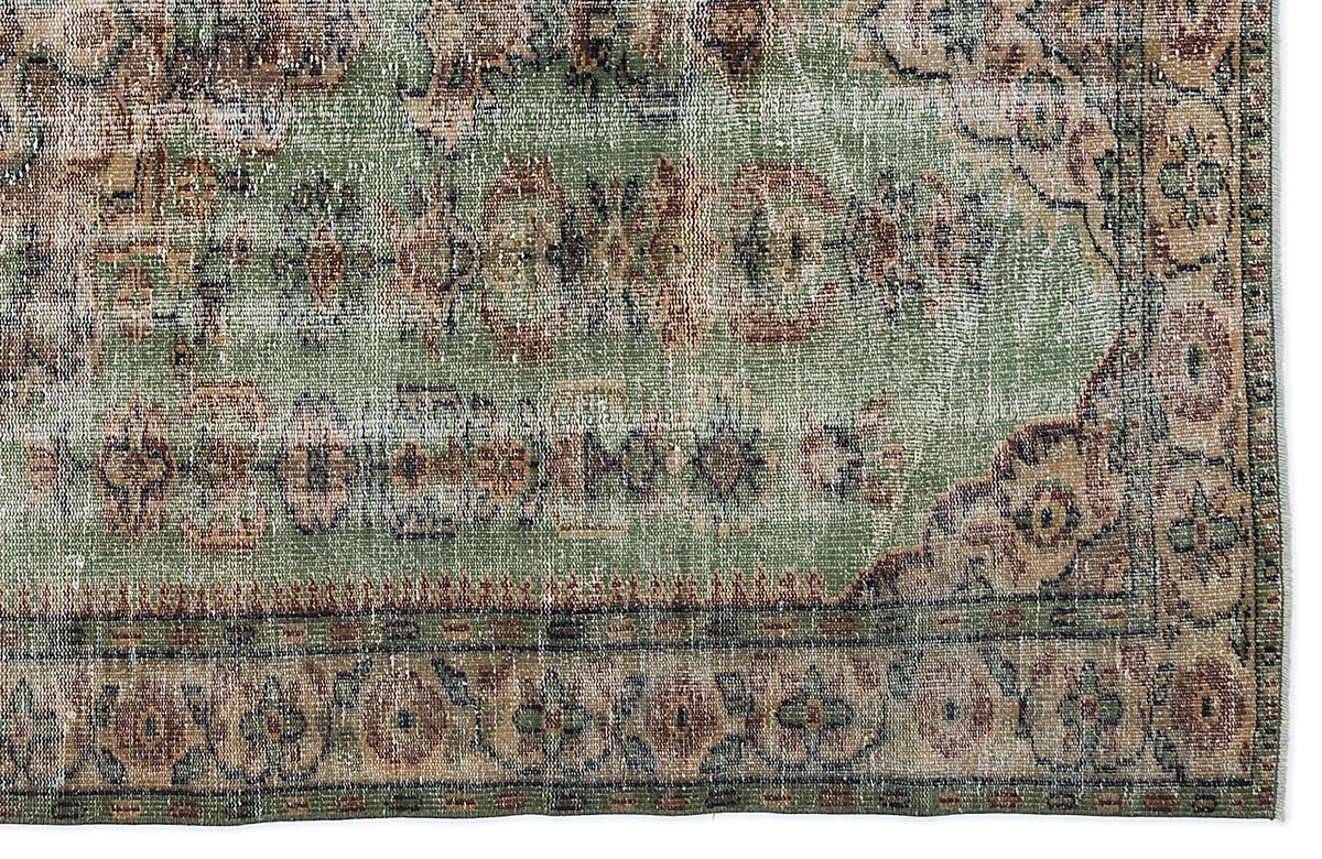 Distressed sage green rug with a traditional floral medallion pattern in brown and cream, isolated on a white background.