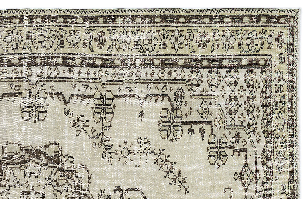 Beige and dark brown vintage-style rug with a distressed geometric and floral border pattern on a white background.