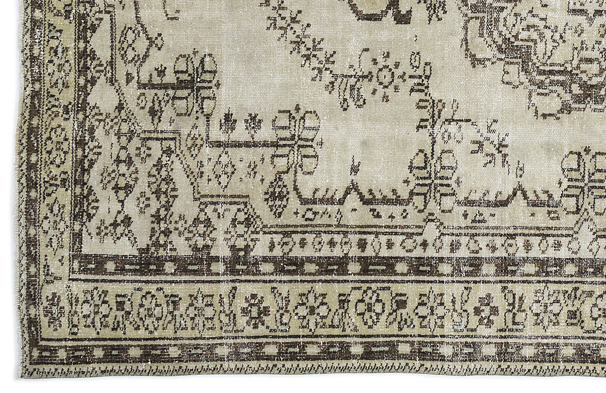 Beige and dark brown vintage-style rug with a distressed traditional floral medallion and geometric border pattern.