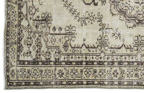 Load image 1 in gallery view. Beige and dark brown vintage-style rug with a distressed traditional floral medallion and geometric border pattern.