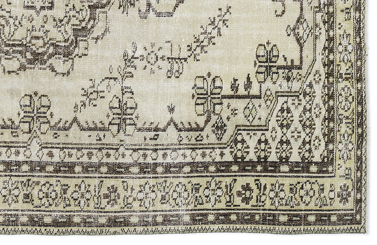 Beige and dark brown vintage-style rug with a distressed floral medallion pattern and geometric border.