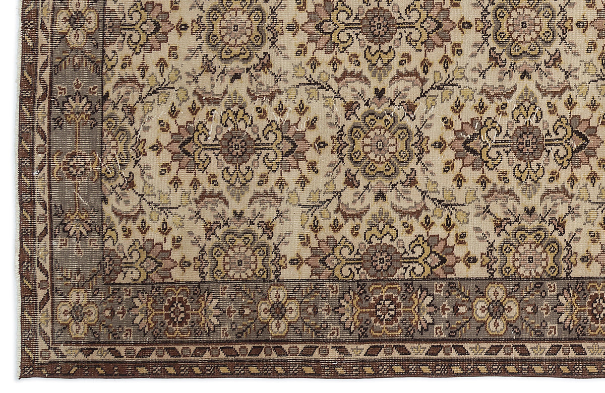 Beige rug with a brown floral medallion pattern and a wide, dark brown decorative border.