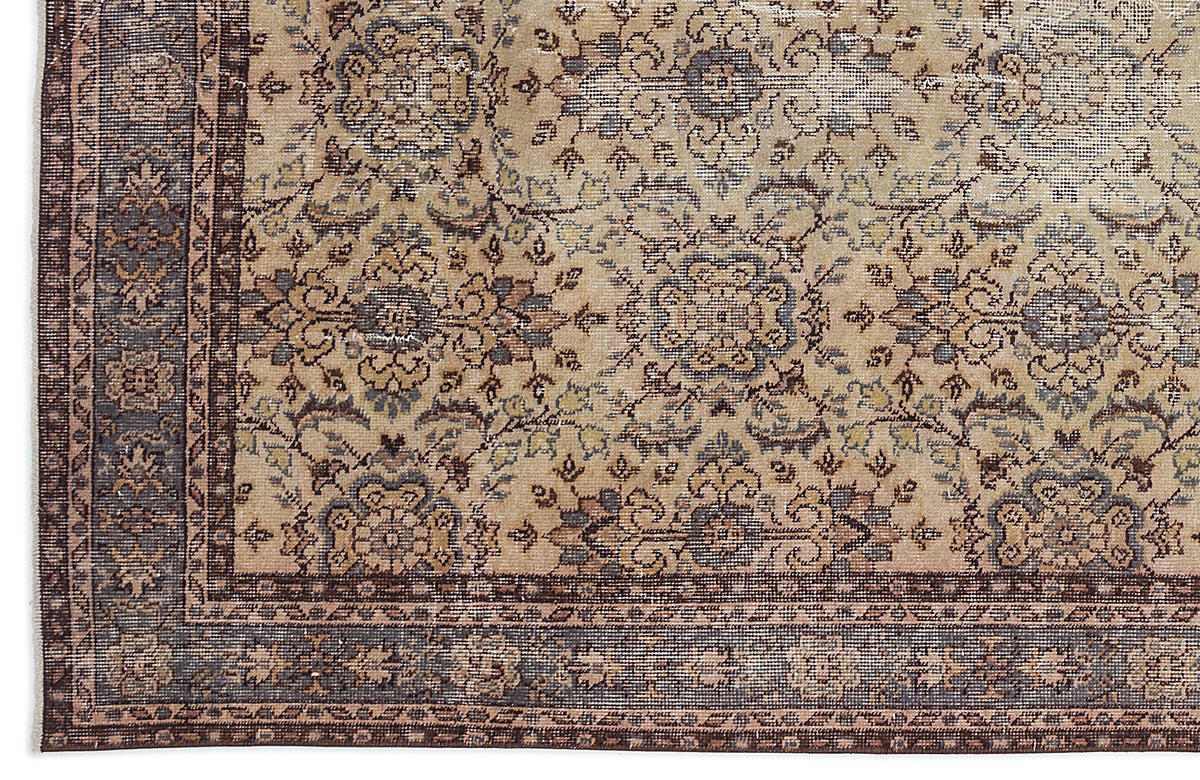 Beige and brown traditional rug with a distressed floral medallion pattern and a dark bordered edge.