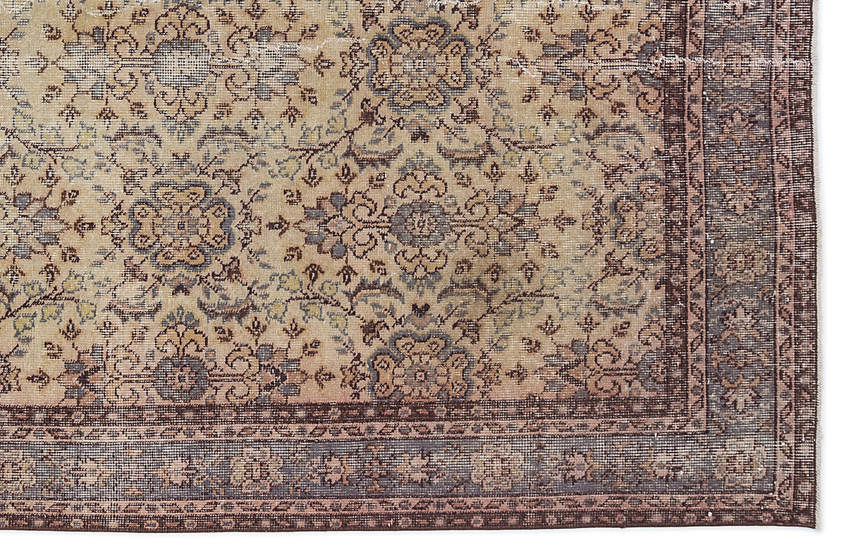 Beige and brown traditional rug with a distressed floral medallion pattern and a detailed border.