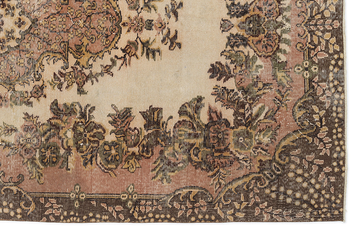 Distressed beige, pink, and brown rug with a traditional floral medallion pattern and ornate border.