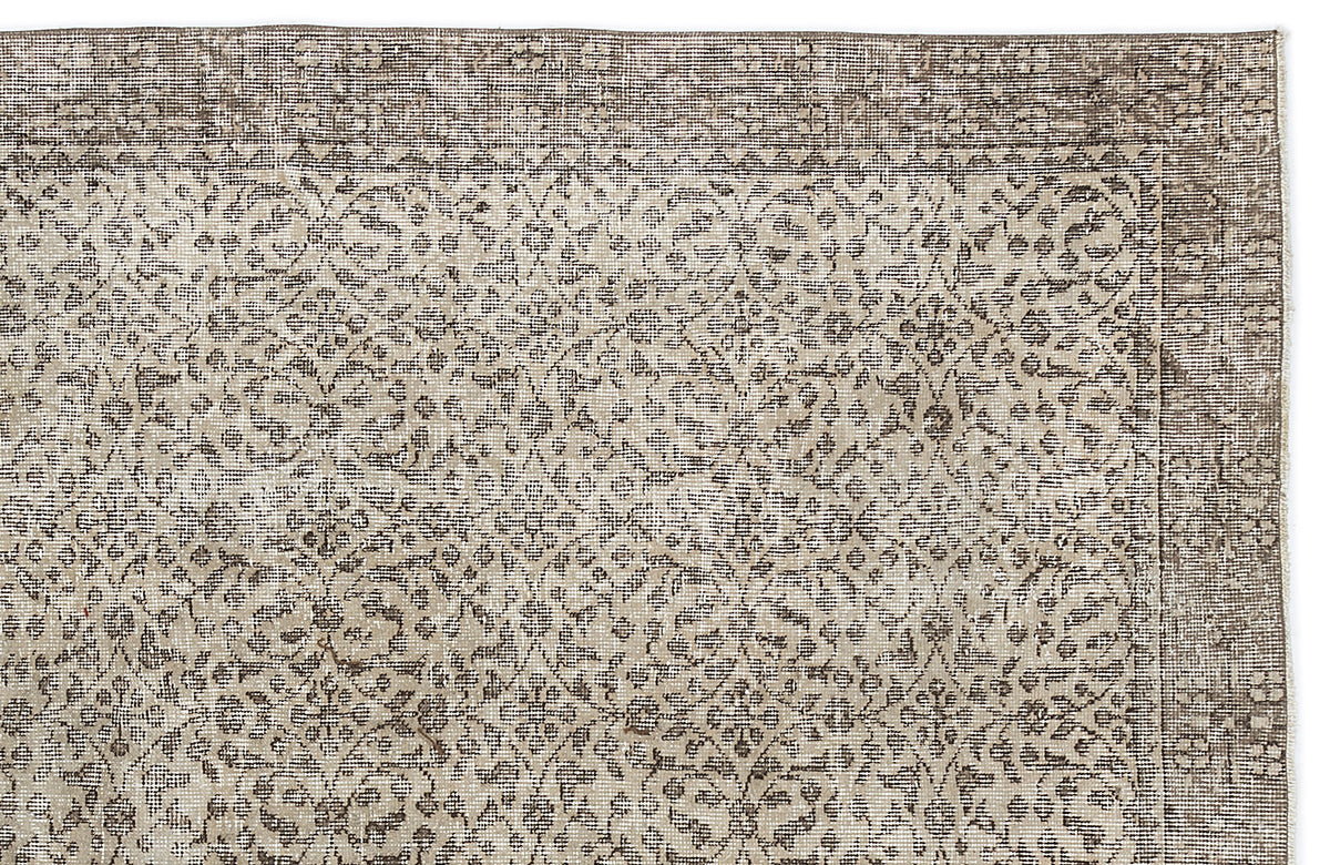 Taupe and cream vintage-style rug with a distressed floral medallion pattern and a wide decorative border.