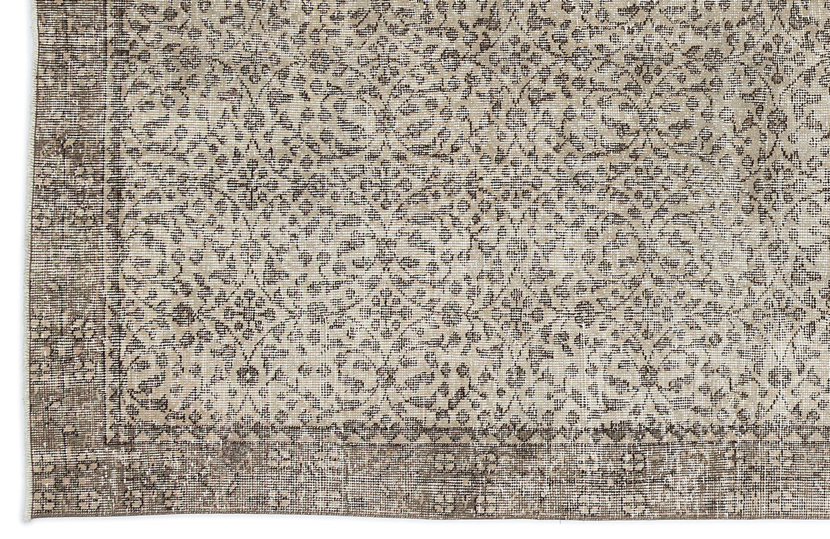 Beige and charcoal grey rug with a distressed traditional floral medallion pattern and a wide decorative border.