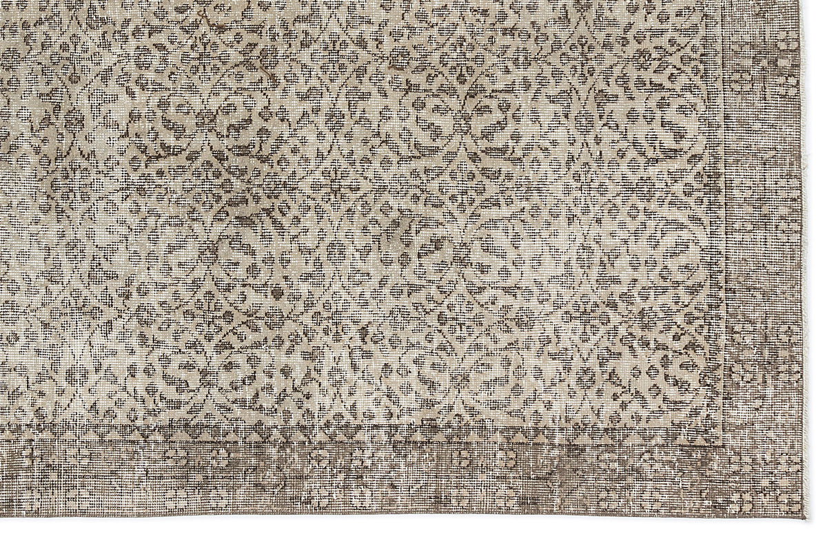 Taupe and cream rug with a distressed traditional floral medallion pattern and a wide geometric border.