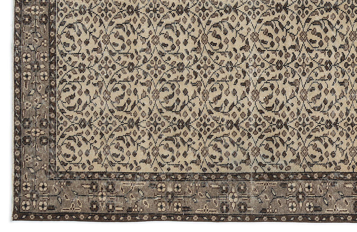 Beige and dark brown rug with a repeating floral vine pattern and a wide, detailed border.