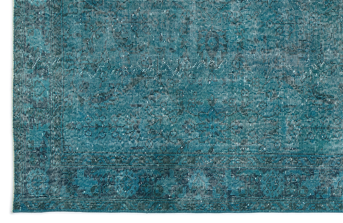 Teal and dark blue distressed rug with a faded traditional medallion pattern.